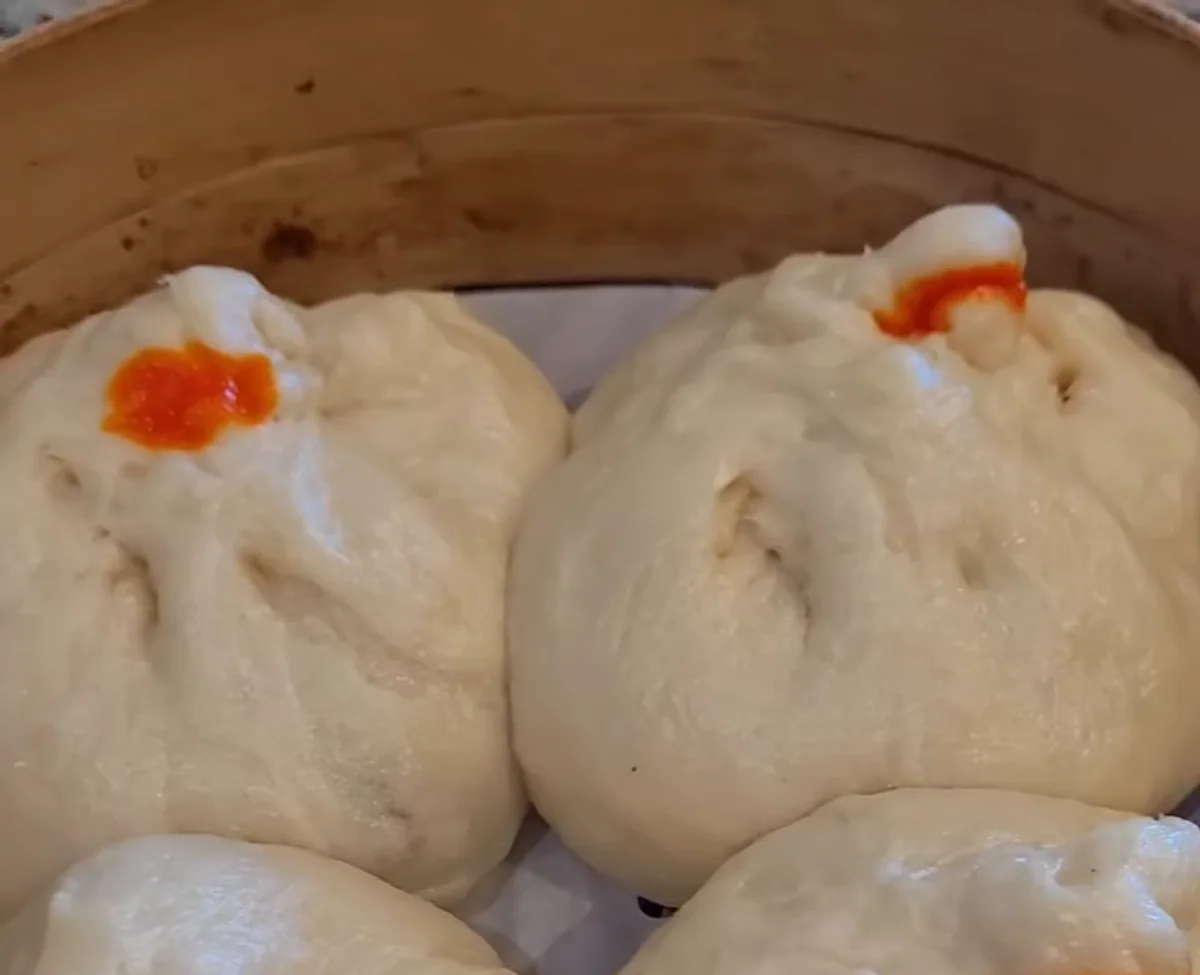 Steamed siopao served in a bamboo basket